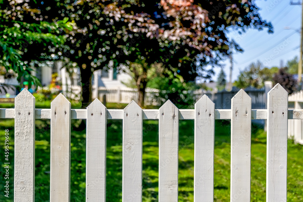 Close up views of a white picket fence in a small town