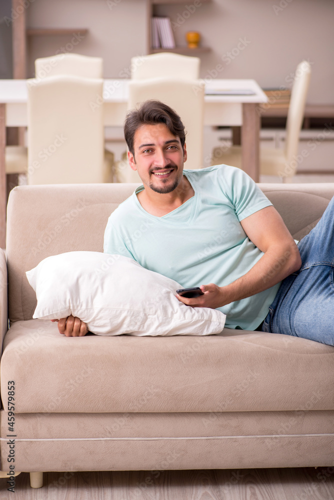 Young man student lying on the sofa at home