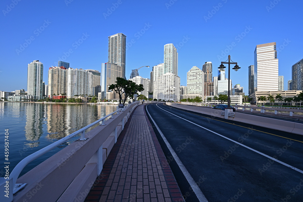 Brickell Key Bridge and City of Miami skyline at sunrise under clear blue sky om tranquil summer morning.