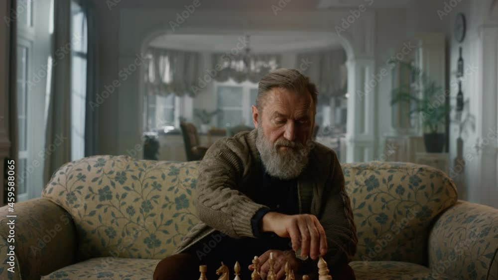Old aged man playing chess board alone at home. Wisdom retirement life concept Old aged man playing chess board alone at home. Wisdom retirement life concept