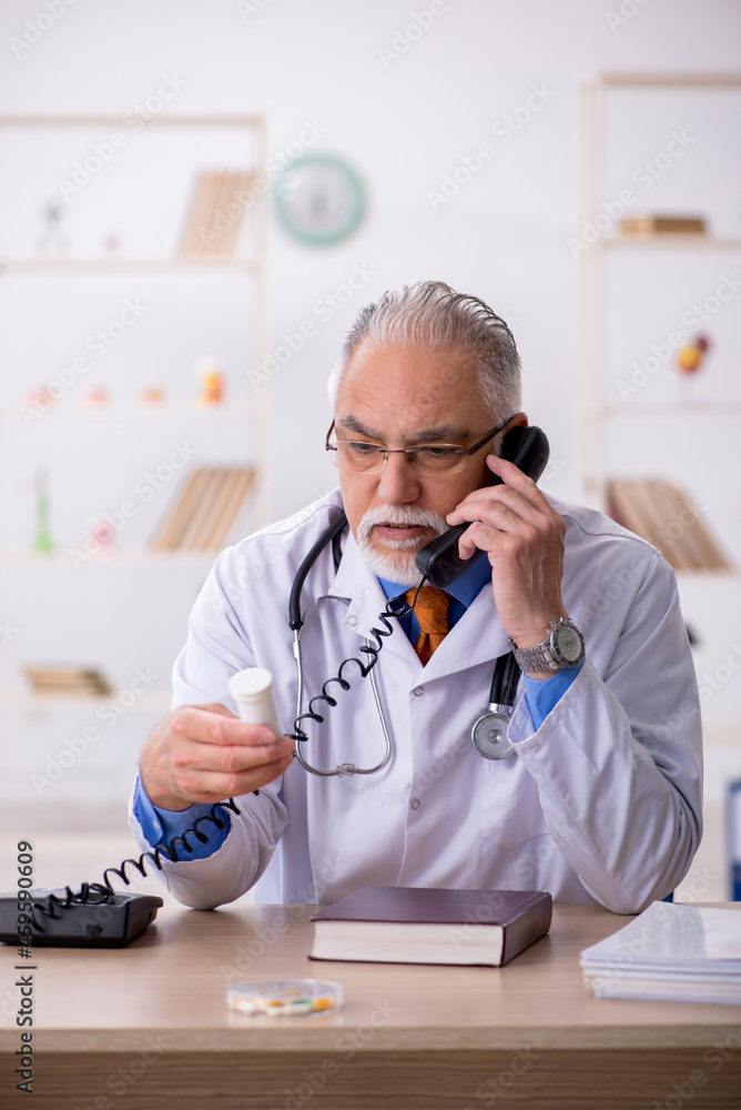 Old male doctor working in the clinic