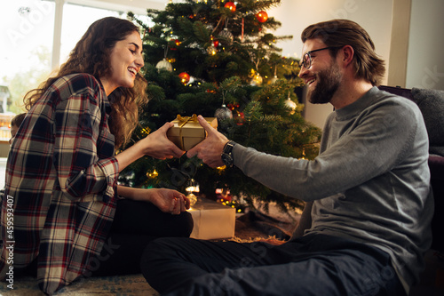 Fotografi Couple exchanging Christmas gifts