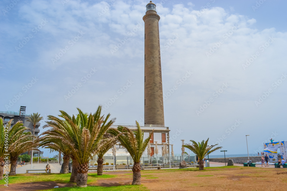 Maspalomas, Las Palmas, Spain, 17.09.2021: Landmark 1890s lighthouse, a popular place to watch the sunset, with a beach, shops and bars nearby.
