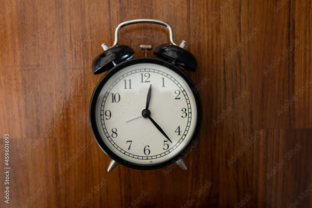 alarm clock on the table with wood background alarm clock on the table with wood background