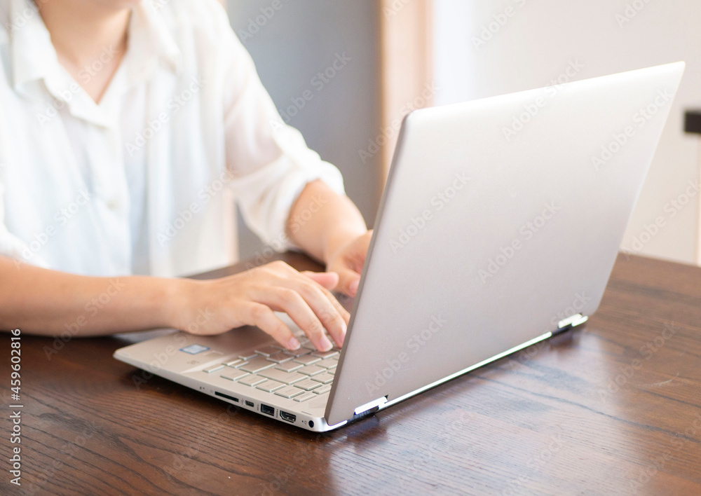 Fototapeta premium 自宅でテレワークをする人の手元とパソコン画面のクローズアップイメージ