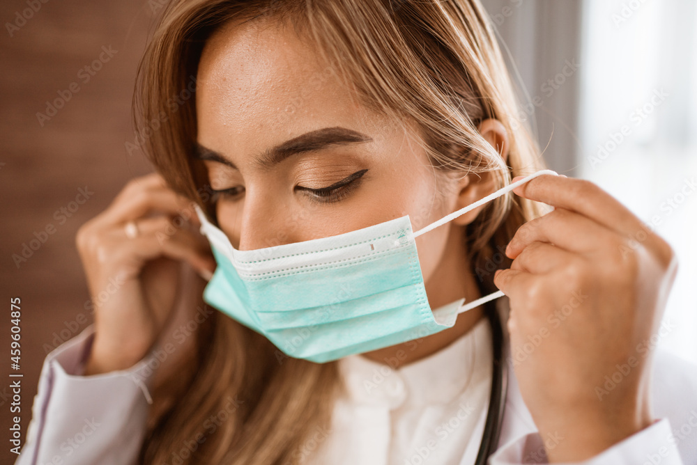 woman doctor wearing medical mask standing looking at camera woman doctor wearing medical mask standing looking at camera