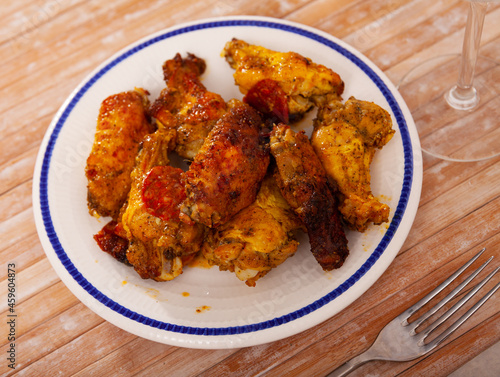 Appetizing baked chicken wings in a plate closeup