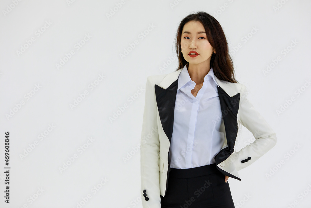 Isolated portrait studio shot of Asian confident professional experienced female businesswoman in stylish fashionable business formal suit and skirt standing posing look at camera on white background