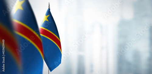 Small flags of Democratic Republic of the Congo on a blurry background of the city