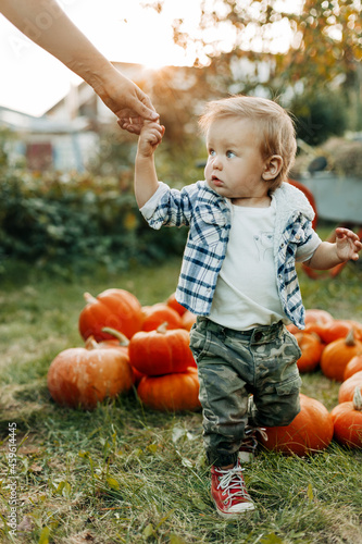 A happy baby is holding hands with his mother during the preparation for the Halloween holiday