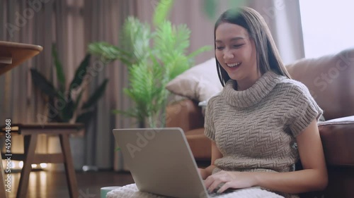 attractive smart asian female adult long black hair working hand use laptop device working online from home at living room on the floor with cheerful freshness expression casual happiness lifestyle 
