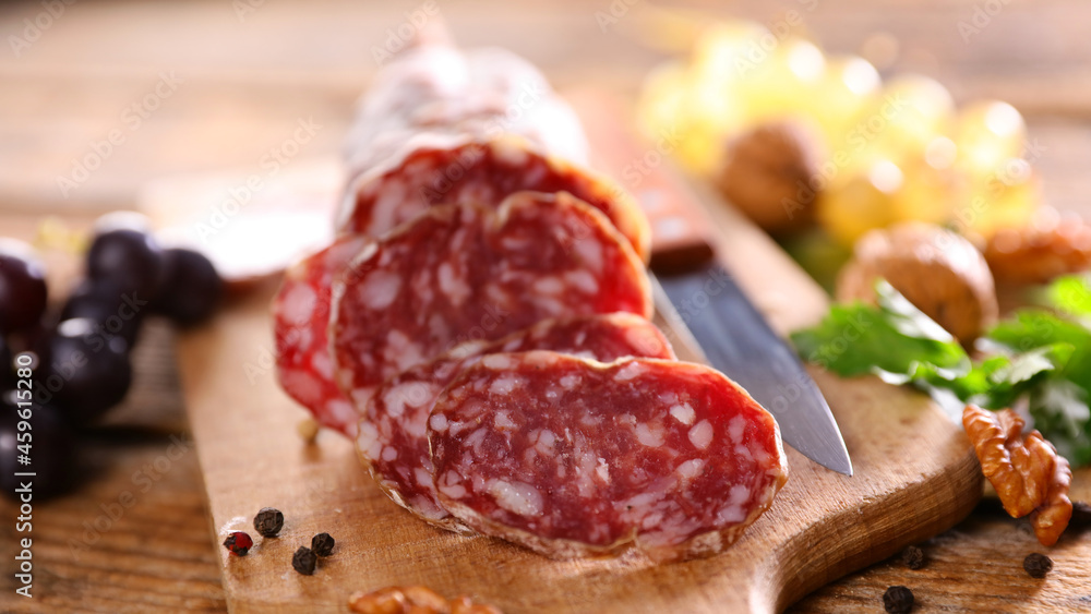 close up on french salami on wooden board