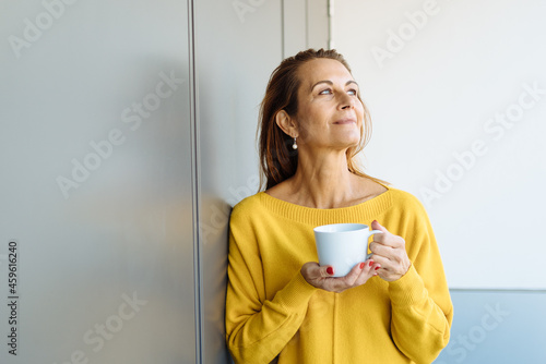 Obraz na płótnie Middle-aged woman standing daydreaming or reliving memories