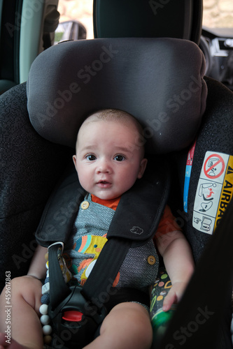 4 month old Caucasian baby sitting in baby carrier safety car seat. child safety transport. family trips. holidays