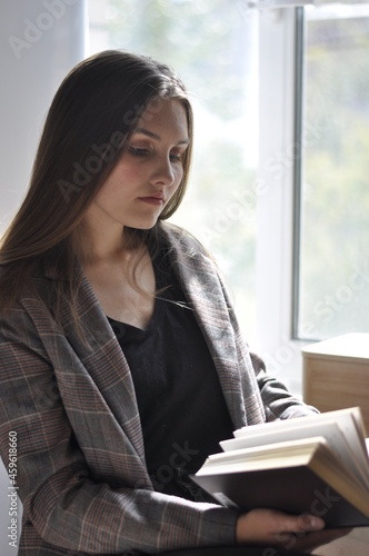 a girl with long hair is reading a book by the window Free Download a girl with long hair is reading a book by the window - GFXLoad