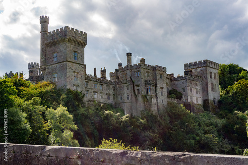 old lismore castle in waterford, ireland with cloudy sky and trees all around