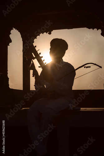 Silhouette of an Indian folk musician playing his instrument in Udaipur, Rajasthan