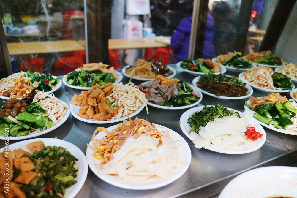 There are a variety of Chinese dishes in the glass showcase There are a variety of Chinese dishes in the glass showcase