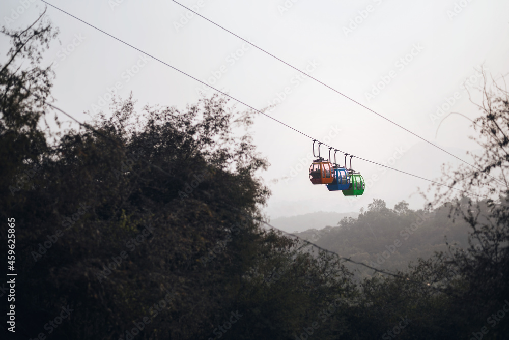 Three trolleys on a ropeway carrying tourists to Karni Mata temple in Udaipur, Rajasthan