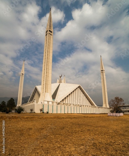 Faisal Mosque Islamabad, Pakistan views with brown grass in foreground on a cloudy day. A clear shot of King Faisal Mosque in Islamabad, Pakistan. photo