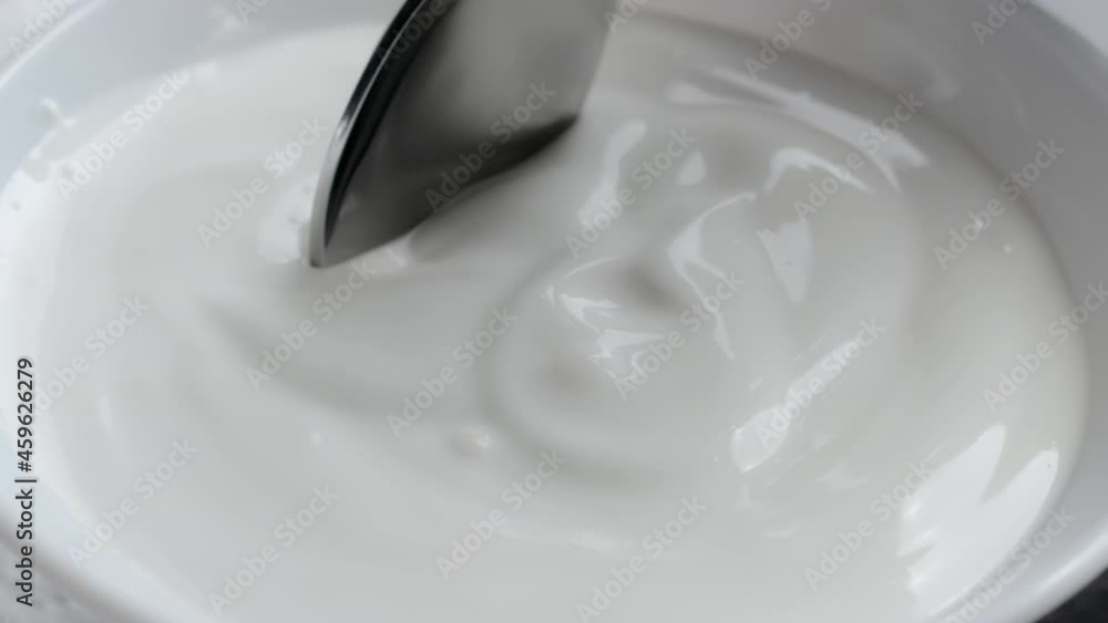 Shooting of bowl with cream and dipped spoon Shooting of bowl with cream and dipped spoon