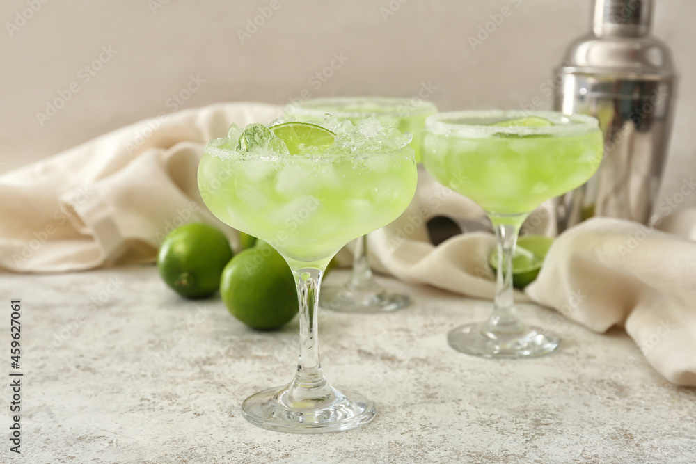Glasses of tasty daiquiri cocktail on light background