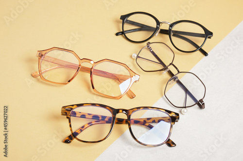 several trendy stylish eyes glasses on beige and gray background copy space