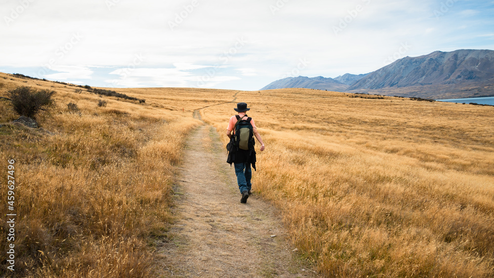 Man walking Peninsula Walkway at Lake Tekapo in autumn, Canterbury, New Zealand. Man walking Peninsula Walkway at Lake Tekapo in autumn, Canterbury, New Zealand.
