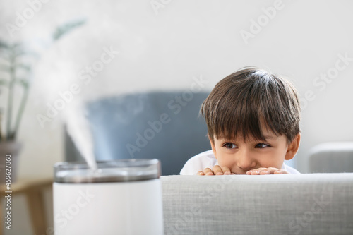 Φωτογραφία Little boy with modern humidifier at home