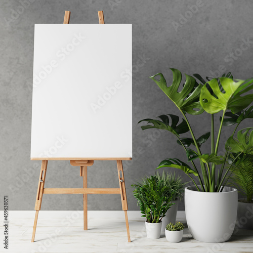 Photo Blank canvas on wooden easel with plant