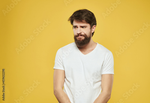 bearded man in a white t-shirt expressive look discontent close-up