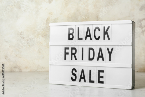 Board with text BLACK FRIDAY SALE on light background