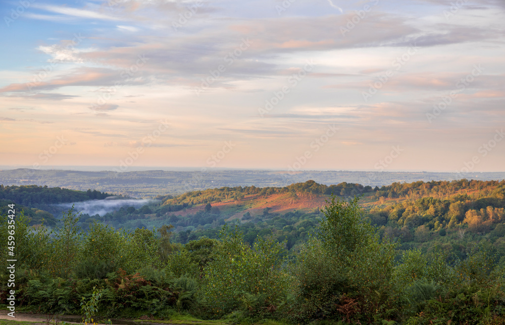 Low clouds and dramatic colours in the sky over the Devils Punch Bowl during sunset on the Surrey Hills near Hindhead south east England Low clouds and dramatic colours in the sky over the Devils Punch Bowl during sunset on the Surrey Hills near Hindhead south east England