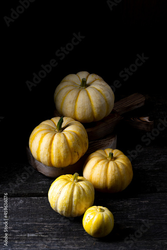 small yellow pumpkins on dark wooden background