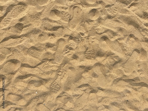 Lots of footstep marks in beach sand.