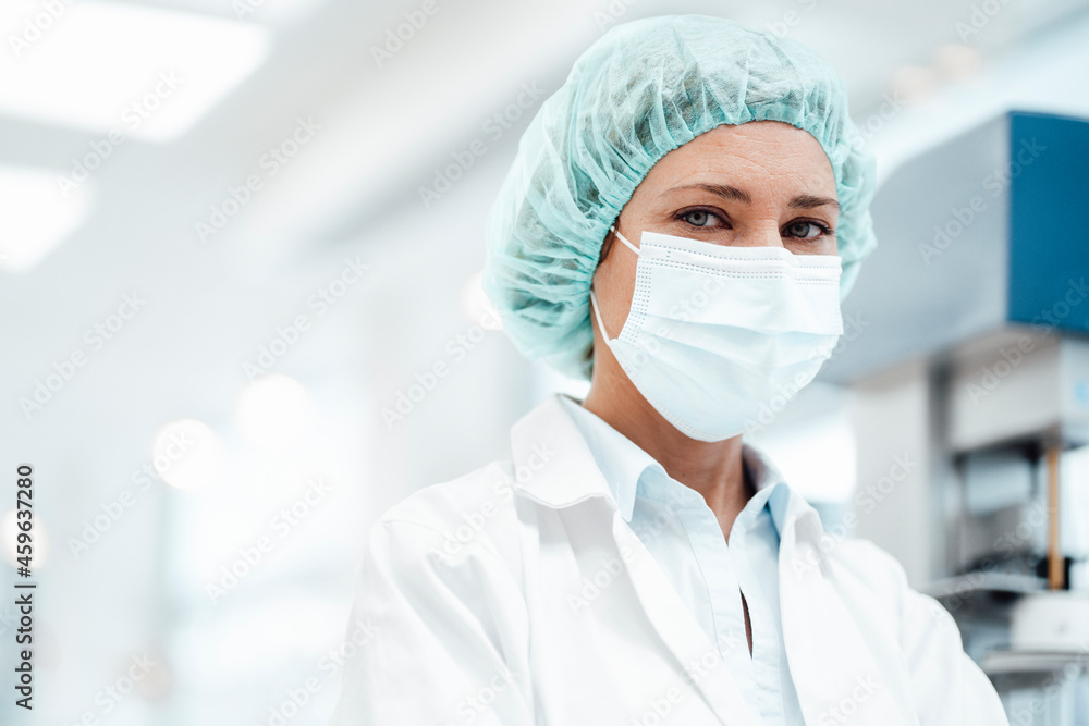 Female pharmacist with surgical cap and protective face mask at pharmacy Female pharmacist with surgical cap and protective face mask at pharmacy