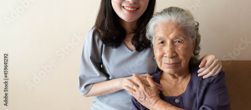 Obraz na płótnie Friendly relationship between family caregiver and happy eldery woman during nursing at home