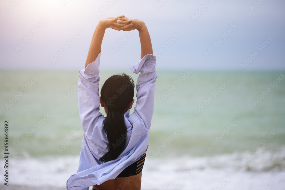 Back view portrait of woman stretching her arms up. Healthy wellness lifestyle. Spiritual health. Personal fulfillment. - obrazy, fototapety, plakaty 
