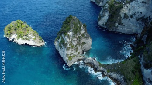 Fly around cliff and rocks over ocean along coast with amazing view on Diamond Beach, Nusa Penida, Bali, Indonesia. High quality 4k aerial footage photo