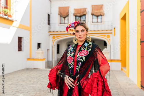 Woman in traditional dress standing at Plaza de toros de la Real Maestranza de Caballeria de Sevilla, Spain photo