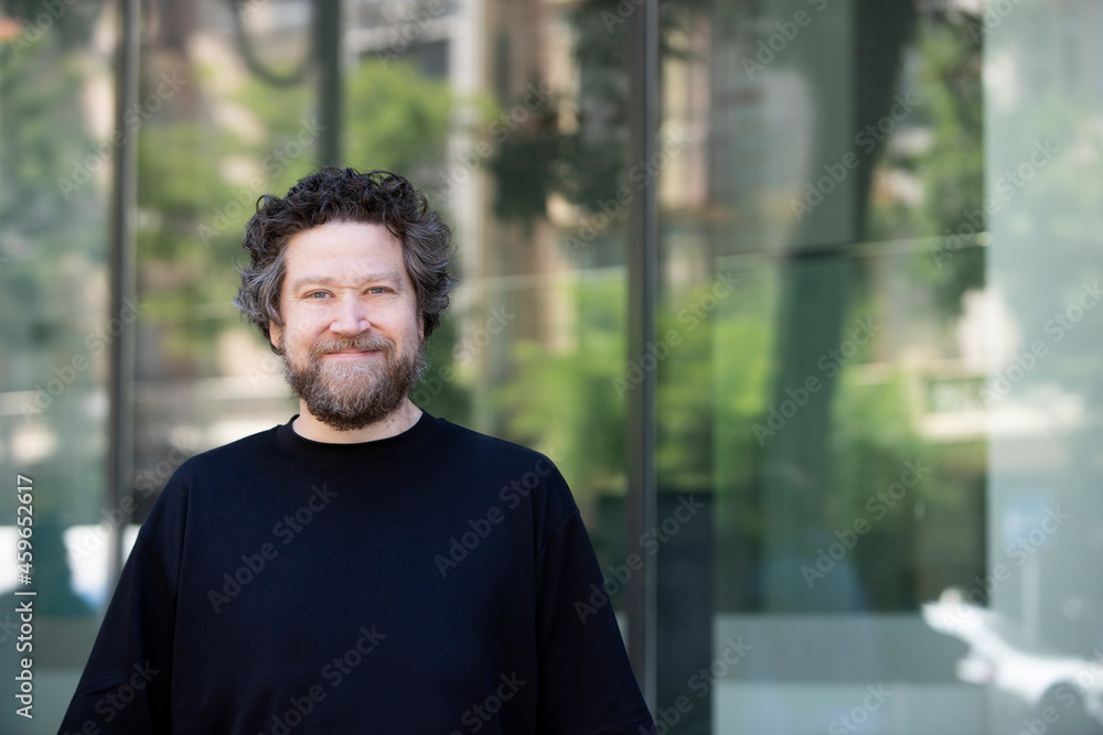 nordic man looking at camera with smile in front of glass background nordic man looking at camera with smile in front of glass background