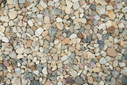 Natural colorful pebble stones background texture with copy space.