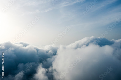 Fototapeta Naklejka Na Ścianę i Meble -  View from above, drone point of view, stunning aerial shot of some fluffy clouds with a bright sun.