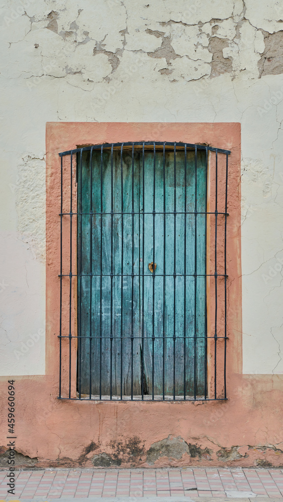Roughed up and deteriorated facade with very rustic old wooden window Roughed up and deteriorated facade with very rustic old wooden window