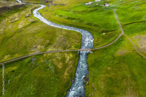Iceland. Aerial view of road and small bridge over blue mountain river. Aerial scenic view of Iceland landscape. Travel vacation concept