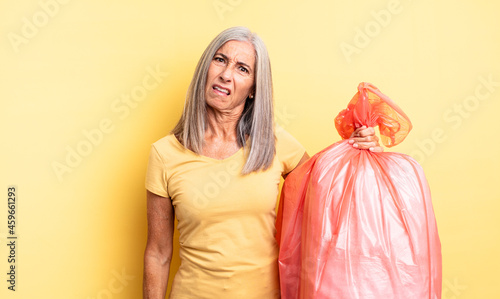 middle age pretty woman feeling puzzled and confused. plastic garbaje bag photo