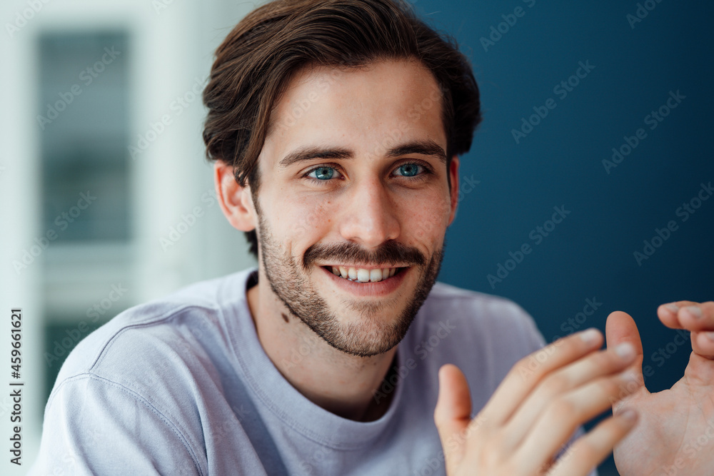 Smiling young man gesturing at home Smiling young man gesturing at home