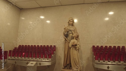 Votive Prayer Candles Surrounding a Statue of the Virgin Mary. photo