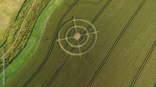 Hackpen hill mysterious wheat field  crop circle design in green furrow farmland aerial high angle view tilt up pull back photo