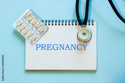 Pregnancy - the words of the doctor in his notebook next to the stethoscope